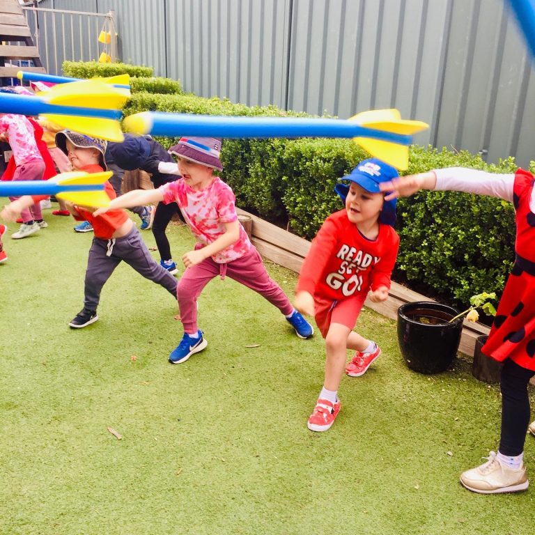 Children launching foam rockets in the outdoor play space at Macarthur Early Learning