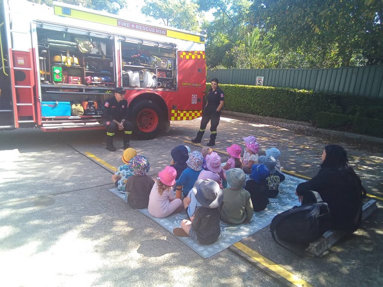 Children sitting together during a Fire and Rescue truck visit at Macarthur Early Learning
